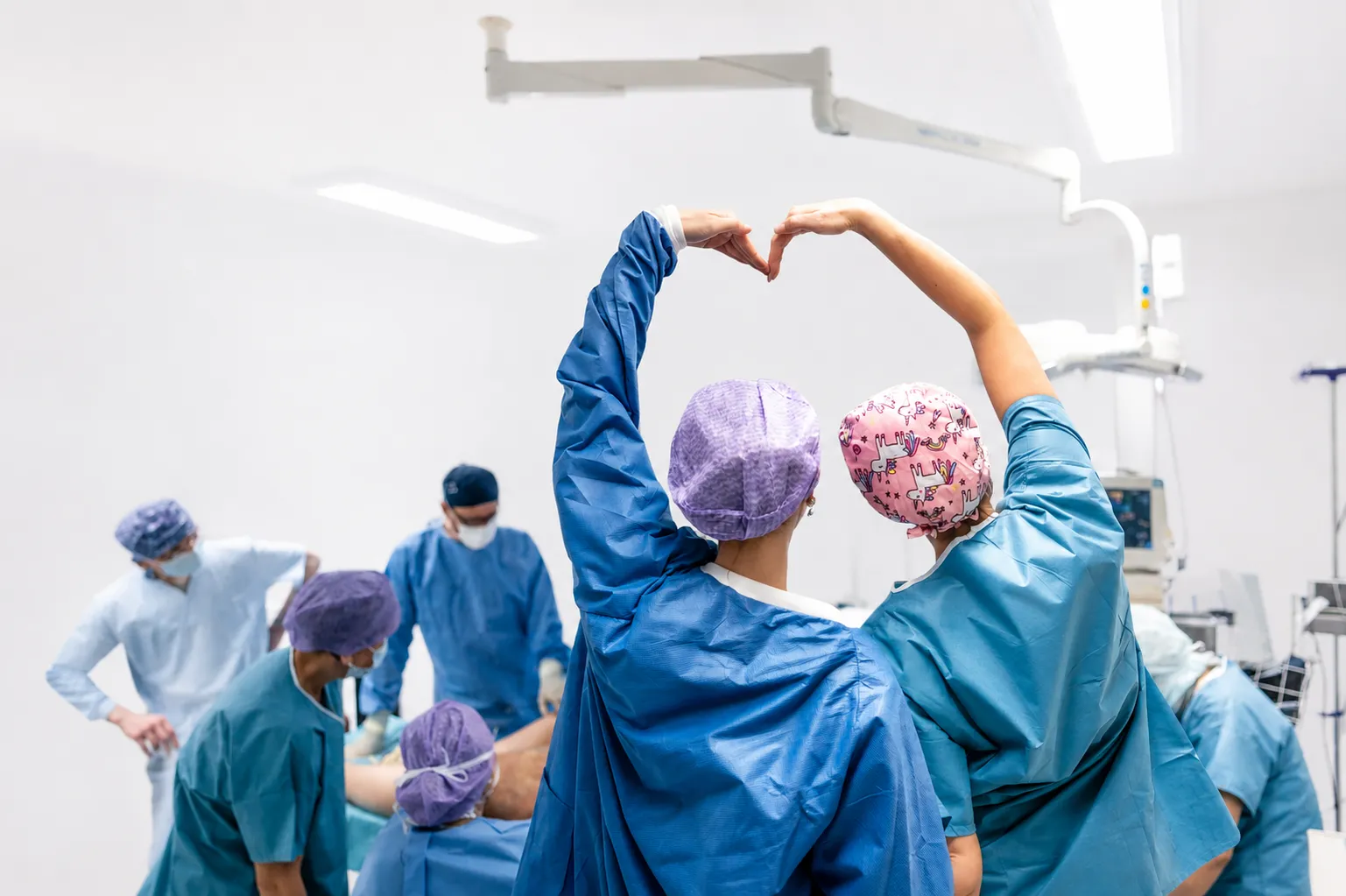 Zwei OP-Mitarbeiterinnen von LipoPlas formen mit erhobenen Armen ein Herz